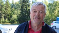 En man kort grått hår står på en parkering.