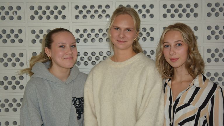 Tre unga kvinnor ler mot kameran.