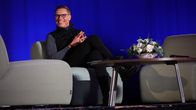 Presidentti Alexander Stubb istuu pöydän ääressä ja hymyilee.
