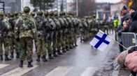 Varusmiehiä marssimassa itsenäisyyspäivän paraatissa Kouvolassa. Pieni Suomen lippu oikeassa reunassa.