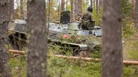Joukkojen harjoituksia maastoajoneuvolla metsäalueella.