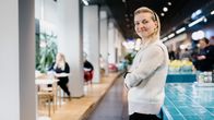 Henkilö seisoo kädet ristissä.