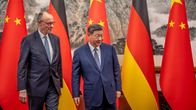 Friedrich Merz ja Xi Jinping tapaavat Pekingissä lippujen edessä.