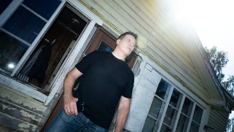 Jouko Ahola seisoo talon edessä.
