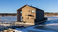 En järnbro leder till flytande huset i Lovisa. Huset har två våningar och flyter på en flotte i en frusen havsvik.