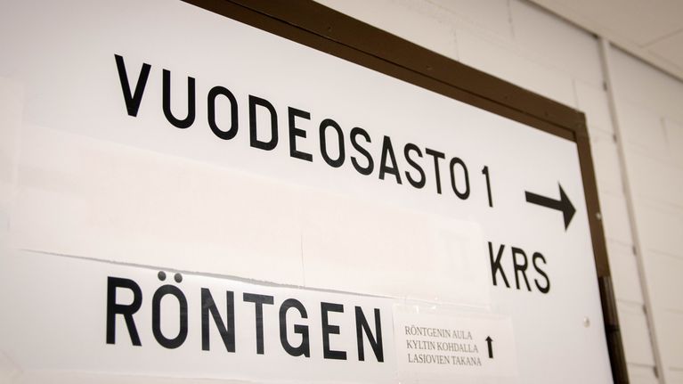 Valkoinen kyltti, jossa mustalla tekstillä "Vuodeosasto 1" ja "Röntgen".