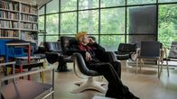 Yrjö Kukkapuro sitter bakåtlutad i stolen Karuselli som han har designat. 