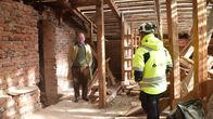 Arthur Aminoff och Benjamin Fröberg inne i ett gammalt hus som resatureras. Vindsvåning, mycket rödtegel och gamla träbjälkar.