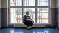 Tutkintavanki Joki istuu vankilan osaston ison ikkunan ääressä ja katselee ulos.
