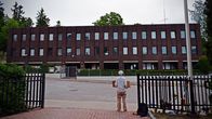 En ensam kvinna står med två skyltar framför det stora ryska konsulatet.