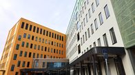 Ett orange och ett grönt höghus med många fönster.