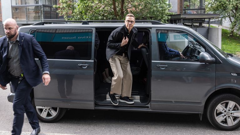 Tasavallan presidentti Alexander Stubb astumassa ulos harmaasta virka-autosta. Turvamies kuvassa vasemmalla etualalla.
