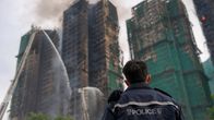 Poliisi katsoo sammutustöitä Hongkongin kerrostalopalossa.