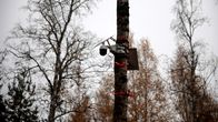 valvontakamera kiinni tolpassa metsässä