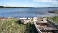 Två små båtar ligger på en strand.