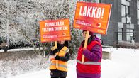 Lakkovahteja kylttien kanssa talvisella pihamaalla.