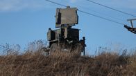 En militär radarstation är placerad på en kulle omgiven av torr vegetation.