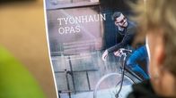 Lähikuva: Henkilö pitää kädessään työnhaun opasta.