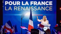 En blond kvinna håller tal framför ett hav av franska flaggor. Bakom henne står det "Pour La France La Renaissance".