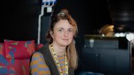 Naispuolinen ohjaaja Alice Rohrwacher istuu nojatuolissa, katsoo kameraan ja hymyilee hieman.