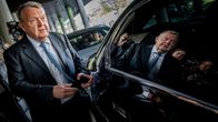 Lars Løkke Rasmussen står mellan en byggnad och en bil.