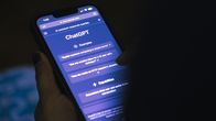 Henkilö pitelee käsissään puhelinta, jossa on auki Chat GPT -tekoäly.