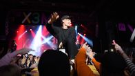 Isac Elliot står på scenen. I förgrunden syns publikens händer. 