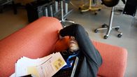 A worker naps on a sofa.