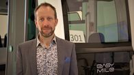 Remotedin palvelupäällikkö Arttu Kotilainen seisoo robottiajoneuvon edessä Tampereen robottiajoneuvojen etävalvontakeskuksella.