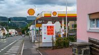 Shell-huoltoasema, jonka hintataulussa on polttoaineiden hintoja. Taustalla katu ja autoja.
