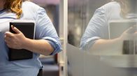 Henkilö pitelee kädessään mustaa kalenteria