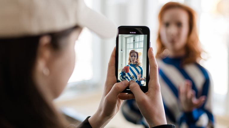 Ylen toimittaja ottaa videota toisesta toimittajasta kännykällä.