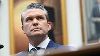  Pete Hegseth istuu mikrofonin vieressä.