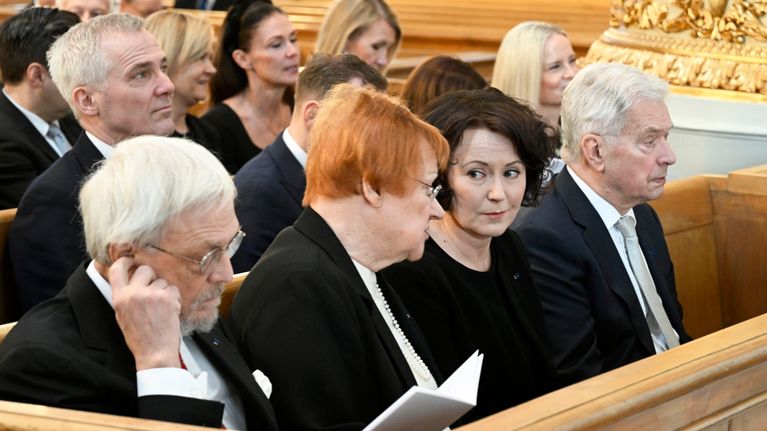 Pentti Arajärvi,  Tarja Halonen, ja Jenni Haukio ja Sauli Niinsitö istuvat jumalanpalveluksessa kirkossa.