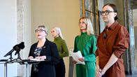 Neljä henkilöä seisoo tiedotustilaisuudessa eduskunnassa.