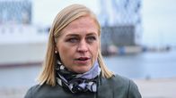 Elina Valtonen seisoo ulkona satama-alueella taustallaan moderni rakennus ja vesistö.