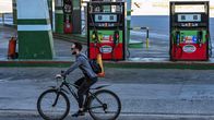 En man cyklar förbi  en bensinstation på Kuba.