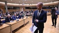 Ville Valkonen paperinippu kädessään eduskunnan neuvotteluhuoneessa.