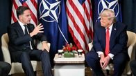 Naton pääsihteeri Mark Rutte ja Yhdysvaltain presidentti Donald Trump istuvat keskustelemassa, taustallaan NATO-liput ja tähtiliput.