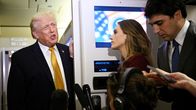 Toimittaja haastattelee Donald Trumpia lentokoneessa.