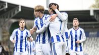 Jalkapallojoukkueen pelaajat juhlivat maalia stadionilla.