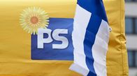 Keltainen teltta, jossa on Perussuomalaisten logo ja Suomen lippu edessä.