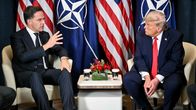 Mark Rutte gestikulerar och Donald Trump lyssnar där de sitter framför USA:s och Natos flaggor. 