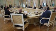 Miehiä istumassa ison pöydän ympärillä, keskellä on Venäjän presidentti Vladimir Putin.