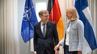 Johann Wadephul ja Elina Valtonen seisovat Naton, Saksan ja Suomen lipun edessä.