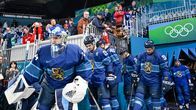 Suomen jääkiekkomaajoukkue kulkee jonossa kaukaloon, taustalla katsomossa yleisö ottaa puhelimillaan kuvia.