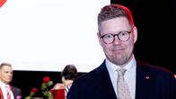 Antti Lindtman lavalla taustalla epätarkkoja henkilöitä.