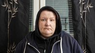 Nainen katsoo kameraa.