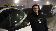Lähitaksin Rovaniemen aluepäällikkö Outi Huttunen nojaa taksin oveen.