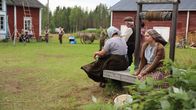 Elokuvan avustajat odottelevat kuvausten alkamista vanhan hirsitalon pihapiirissä Suvannon kylässä.